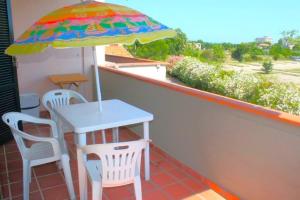 - Balcón con mesa, 2 sillas y sombrilla en BILO CAMERINO a due passi dal mare, con wifi, en Marcelli
