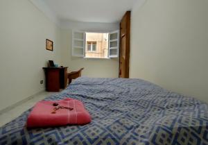 a room with a bed with a red bag on it at Kemet - a private room at Shared apartment For Men only No Ladies allowed غرفة خاصة في شقة مشتركة للرجال فقط ممنوع السيدات in Alexandria