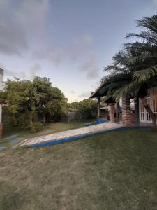 une maison avec un palmier et une passerelle dans l'établissement Suíte quádrupla Odoyá Beach, à Conde