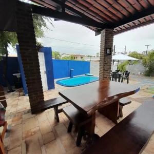 une terrasse avec une table et une piscine dans l'établissement Suíte quádrupla Odoyá Beach, à Conde
