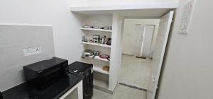 a small kitchen with a sink and a microwave at SAIBALA HOMESTAY - AC 3 BHK NEAR AlRPORT in Chennai