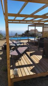 a wooden deck with a table and chairs next to a pool at Höhlenapartment in Güimar