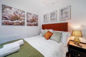 a bedroom with a bed and paintings on the wall at The Eden Loft: A Stylish Retreat in Strabane