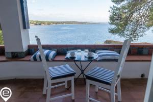 un tavolo e sedie su un balcone con vista sull'acqua di Alghero Sea Whisper a Fertilia