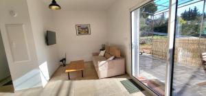 ein Wohnzimmer mit einem Sofa und einer Glasschiebetür in der Unterkunft Jolie maison neuve entre mer et colline en Provence in Ollioules
