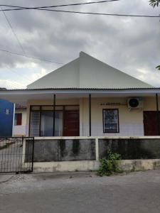 a small white house with a pitched roof at OYO 93173 Khazanah Room Syariah in Yogyakarta