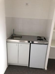 uma pequena cozinha com um lavatório e um fogão em Aladin resort em Bouconvillers