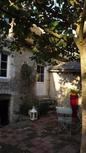 LE BONHEUR DES HÔTES في Suèvres: منزل أمامه طاولة وكرسي