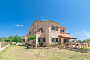 an old stone house with green shutters on a yard at Villa Els Amatllers by Sealand Villas in Port de Pollensa