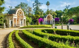 een park met een gebouw en een tuin met struiken bij casadifederica in Palermo