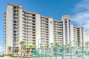 a large white building with palm trees in front of it at Phoenix VI 807 in Orange Beach