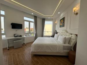 a bedroom with a white bed and a television at Paris Hotel Châu Đốc in Chau Doc