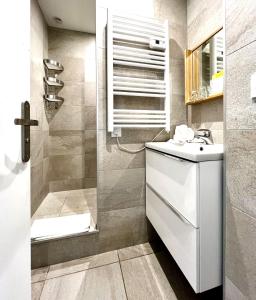 a bathroom with a sink and a shower at Hotel L'Escapade in Le Lavandou