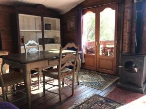 a dining room with a table and a wood stove at Casa del Paso in Bolulla