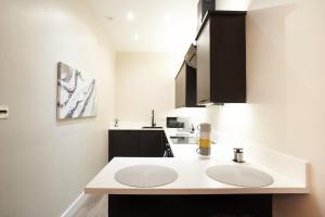 une cuisine blanche avec deux lavabos dans l'établissement Lovely, Recently Refurbished Two Bedroom Apartment, à Glasgow