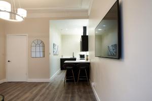 a kitchen with a bar with stools and a mirror at Lovely, Recently Refurbished Two Bedroom Apartment in Glasgow