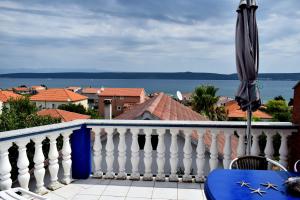 - un balcon avec un parasol et une vue sur l'eau dans l'établissement J&D, à Dobropoljana