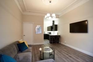 a living room with a couch and a table at Lovely, Recently Refurbished Two Bedroom Apartment in Glasgow