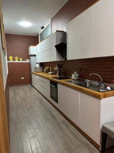 eine Küche mit weißen Schränken und Holzböden in der Unterkunft Dry Lake Apartment in Tirana