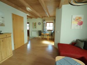 ein Wohnzimmer mit einem roten Sofa und einem Tisch in der Unterkunft Ferienwohnung Stuiber in Haarbach