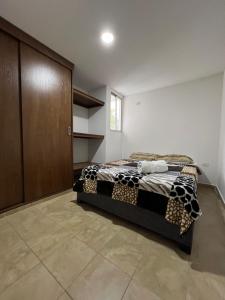 a bedroom with a bed and a wooden cabinet at Gianina house in Barranquilla