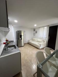a kitchen and a living room with a couch at Gianina house in Barranquilla