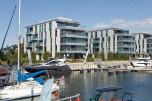 a group of boats docked in a marina with buildings at Yacht Park Marina in Gdynia