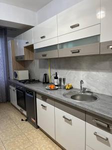 a kitchen with a sink and a stove at Apartment for relax in Chişinău