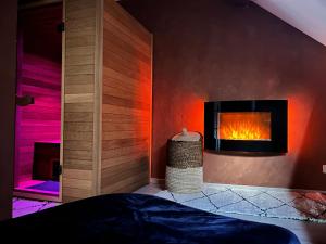 a bedroom with a fireplace in the wall at Pause Cachée in Walhain-Saint-Paul