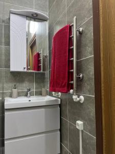 a bathroom with a white sink and red towels at Apartment for relax in Chişinău