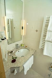 a bathroom with a sink and a mirror at Alpenhof in Gauting