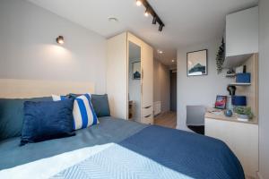a bedroom with a blue bed and a desk at Cozy City Living Ensuites in trendy Wick Park Student Accommodation in London