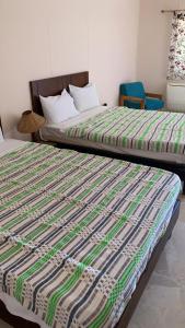 two beds sitting next to each other in a room at Sayadeen Village - Red Sea Riviera in Nuweiba