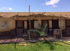 an outside view of a house with chairs in front of it at Sayadeen Village - Red Sea Riviera in Nuweiba
