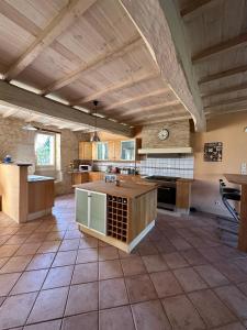 een grote keuken met houten plafonds en een grote kamer bij Maison Lafuge - Piscine au cœur des vignes in Doulezon