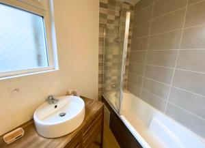 a bathroom with a sink and a bath tub at Le Général - 4 personnes - Poitiers - La Conciergerie in Poitiers