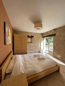 een slaapkamer met een groot bed in een kamer bij Maison Lafuge - Piscine au cœur des vignes in Doulezon
