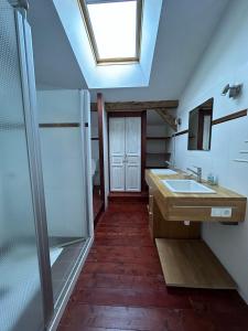 een badkamer met een douche, een wastafel en een dakraam bij Maison Lafuge - Piscine au cœur des vignes in Doulezon