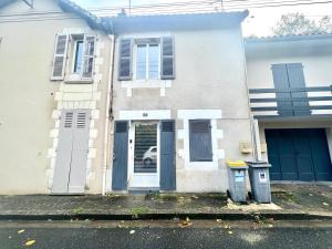 uma casa branca com portas azuis e duas latas de lixo em La Benoîtine - Jolie Maison à Saint Benoît em Saint-Benoît