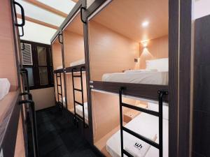 a room with three bunk beds and a mirror at Wink at Perak Road in Singapore