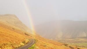 a rainbow on the side of a road at Scafell and Wasdale Cottages in Nether Wasdale