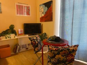 a living room with a table and a television at Sakè Loft in Catania