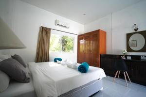 a bedroom with a bed and a desk and a window at Avare Seaside House Krabi in Ao Nam Mao