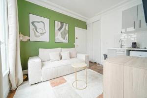 ein Wohnzimmer mit einem weißen Sofa und einem Tisch in der Unterkunft Apartment proche Vaugirard - Sauge - III in Paris