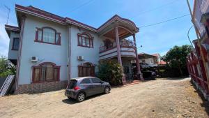 a small car parked in front of a house at OYO 93176 Hotel Savira in Barru