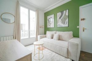 ein Wohnzimmer mit einem Sofa und einem Fenster in der Unterkunft Apartment proche Vaugirard - Sauge - III in Paris