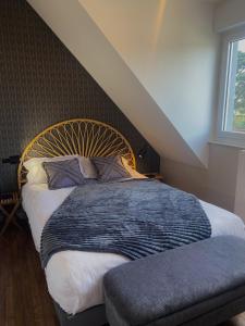 a bedroom with a large bed with a wooden headboard at Villa des Pins in Jullouville-les-Pins