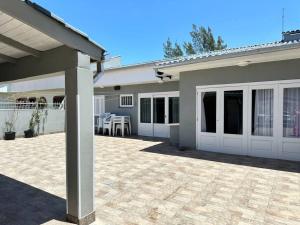 Cette maison dispose de portes blanches et d'une terrasse. dans l'établissement Belíssima casa a perto da praia, à Tramandaí