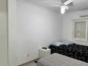 - une chambre avec 2 lits et une fenêtre dans l'établissement Belíssima casa a perto da praia, à Tramandaí
