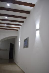 um quarto com uma parede branca com luzes no tecto em La Dimora Di Garibaldi em Augusta